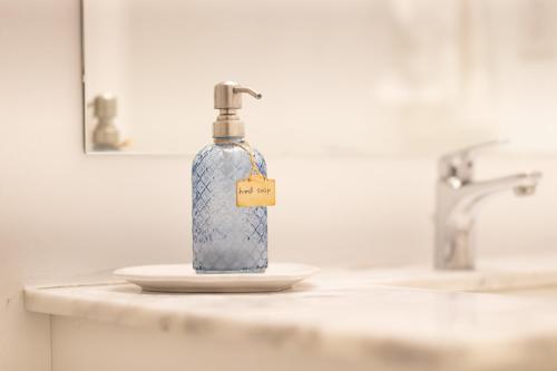 a bottle of soap sitting on a counter in a bathroom at Downsview Park Luxury Townhome near Yorkdale Transit in Toronto
