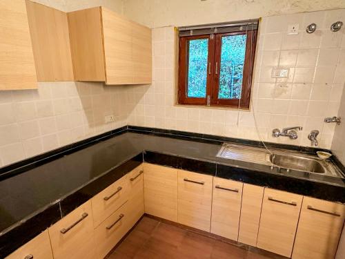 an empty kitchen with a sink and a window at Bird Songs in Rāmgarh