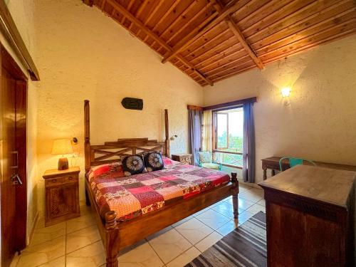 a bedroom with a bed in a room with a window at Bird Songs in Rāmgarh