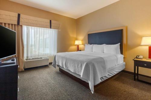a bedroom with a large bed and a flat screen tv at Cambria Hotel Denver International Airport in Aurora