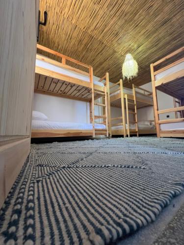 a room with two bunk beds and a rug at Surf Therapy in Agadir