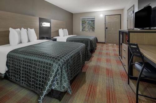 a hotel room with two beds and a flat screen tv at Rodeway Inn Ardmore I-65 in Elkton