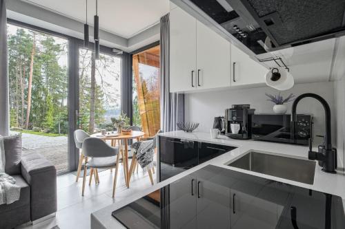 a kitchen with white cabinets and a table with chairs at Apartament Białka SKI - 200m do Term Bania, blisko natury in Białka Tatrzańska