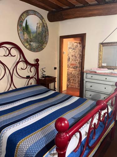 a bedroom with a red and blue bed with a dresser at W il silenzio! in Gualdo