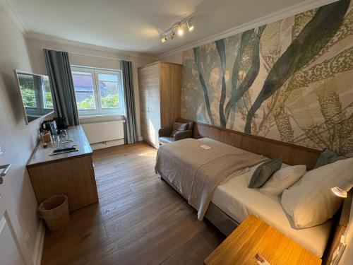 a bedroom with a bed and a painting on the wall at Boardinghouse Robbe in Westerland