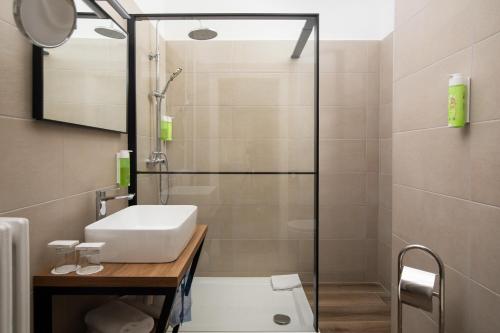 a bathroom with a sink and a shower at Brijuni Hotel Neptun in Fažana
