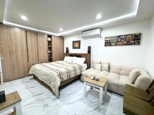 a hotel room with a bed and a couch at Velmora Villas Room 12 in Abu Dhabi