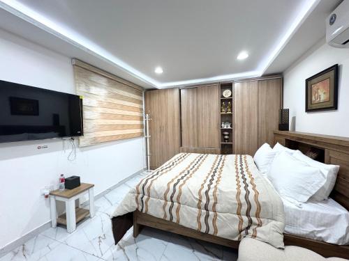a bedroom with a bed and a flat screen tv at Velmora Villas Room 12 in Abu Dhabi