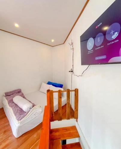 a room with a bed and a tv on the wall at Teras Candi Villa in Diyeng