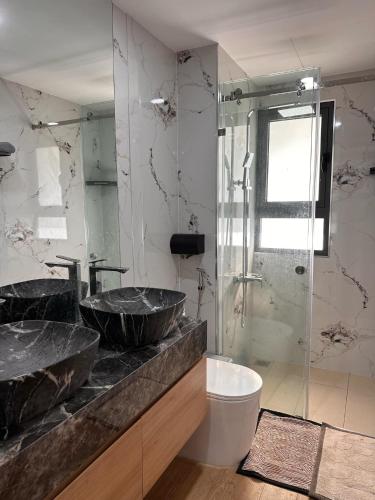 a bathroom with two sinks and a glass shower at Căn Hộ Biên Hoà in Bien Hoa