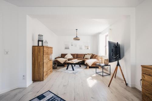 a living room with a couch and a tv at Gartenidyll in Zingst