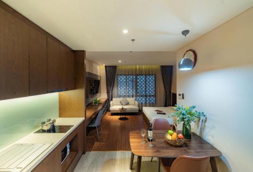 a kitchen and a living room with a table at DHTS Business Hotel & Apartment in Ho Chi Minh City