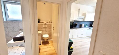 a kitchen with white cabinets and a toilet in it at Großzügiger Wohntraum mit 4 Schlafzimmern nur 8 Gehminuten vom Europa-Park in Rust