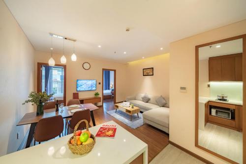 a living room and kitchen with a couch and a table at DHTS Business Hotel & Apartment in Ho Chi Minh City