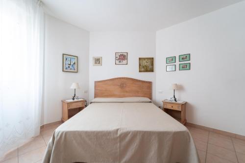 a bedroom with a large bed with two night tables at Rubens in Alghero