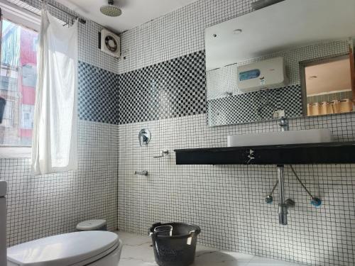 a bathroom with a toilet and a sink and a mirror at Hotel Pahalgam Villas in Pahalgām
