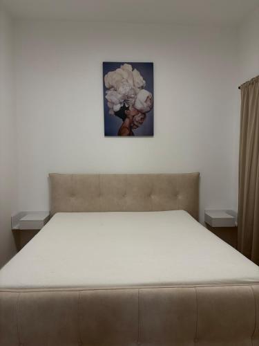 a bed in a bedroom with a picture on the wall at Central nude oasis 2 in Makarska