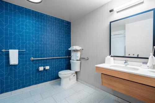 a bathroom with a toilet and a sink and a mirror at Spark by Hilton Atlanta Kennesaw Town Center in Kennesaw