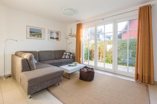 a living room with a couch and a large window at Neuland in Zingst