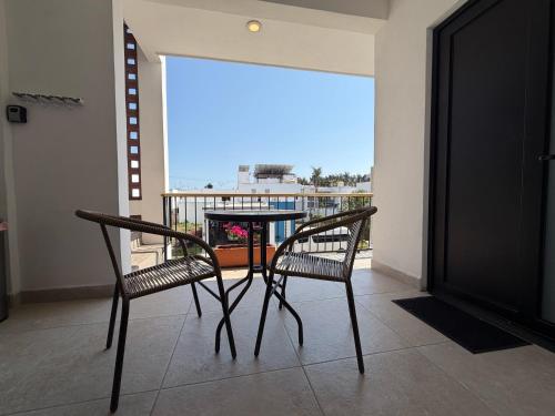 a table and chairs on a balcony with a view at Casa DOS21 Boutique Apartments Playa Sur in Mazatlán