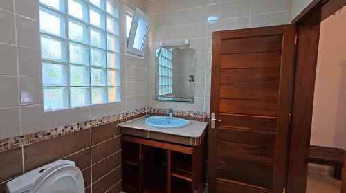 a bathroom with a sink and a toilet and a window at Le Lagon Bleu in Antsatrakolo