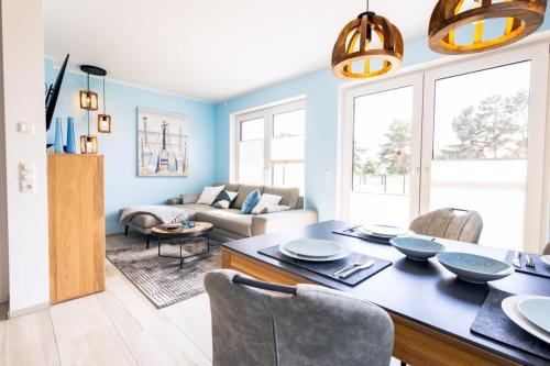 a living room with blue walls and a table and chairs at Ostseelodge zwei in Fuhlendorf