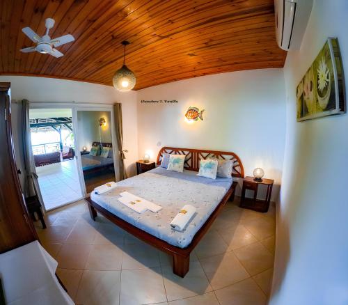 a bedroom with a bed and a wooden ceiling at Le Lagon Bleu in Antsatrakolo