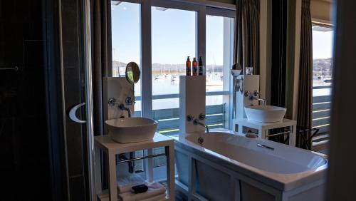 a bathroom with two sinks and a large window at The Lofts Boutique Hotel in Knysna