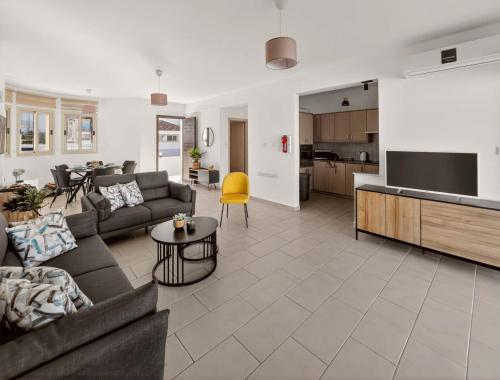 a living room with a couch and a table and a kitchen at Villa Allegra in Protaras