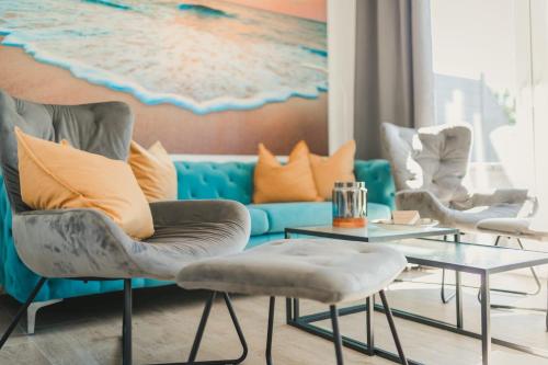 a living room with a blue couch with orange pillows at Zum Koi Fischer in Fuhlendorf