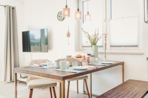 a dining room table with two chairs and a wooden table at Zum Koi Fischer in Fuhlendorf