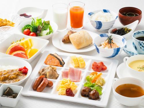 a table filled with plates of food and drinks at Yatsushiro Grand Hotel in Yatsushiro