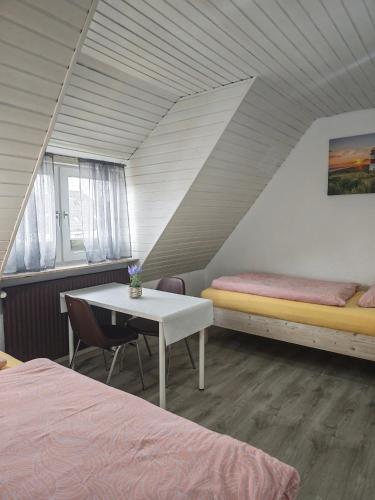 a room with two beds and a table in a room at Pension Highway - Osnabrück Klarastr 11 in Osnabrück