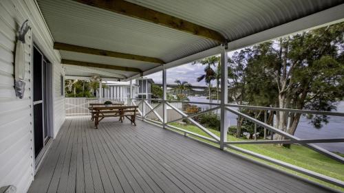 a porch with a bench and a view of the water at 'Fair View On Daleys' by HolidayCo in Daleys Point