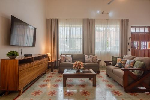 a living room with a couch and a flat screen tv at La Casa del Jaguar in Mérida