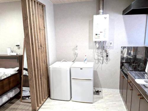 a kitchen with a white refrigerator and a sink at Room One in Aomori