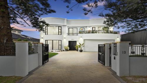 a white house with a driveway at 'Aloha Beach Retreat' by HolidayCo in Norah