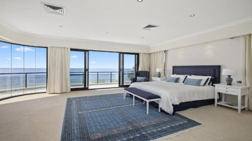 a bedroom with a large bed and large windows at 'Aloha Beach Retreat' by HolidayCo in Norah