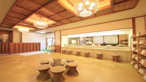 a salon with a row of stools in a room at Hatoya Hotel in Ito