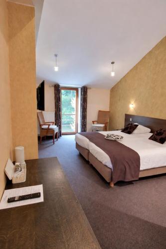 a bedroom with a large bed and a living room at Hôtel La Ferme de Sy in Ferrières