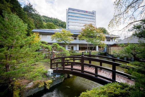 a bridge over a river in front of a building at Yumoto Kissho in Osaki