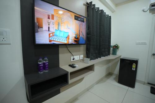 a flat screen tv on a wall in a room at Hotel Flamount Arka Studios in Hyderabad