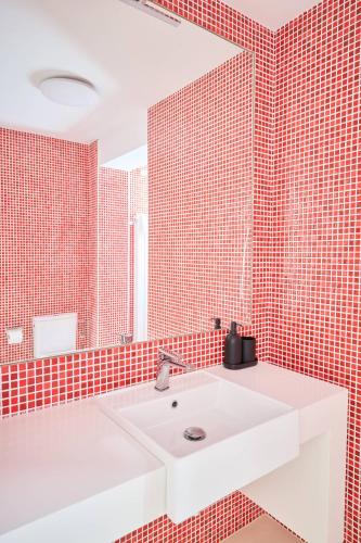 a bathroom with a white sink and red tiled walls at Casa Rural Las Bengoas in Alesanco