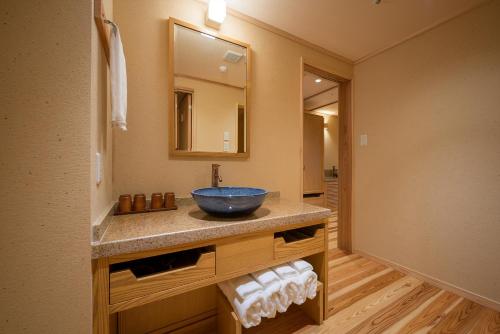 a bathroom with a bowl sink and a mirror at Yumoto Kissho in Osaki