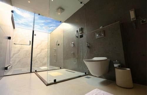 a bathroom with a glass shower and a toilet at Vinaika Eco-Resort in Rānchī