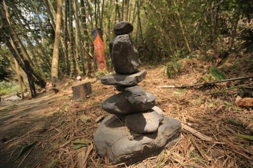 a statue of a person sitting on top of a stack of rocks at HOTEL LA SELVA Reserva in La Vega