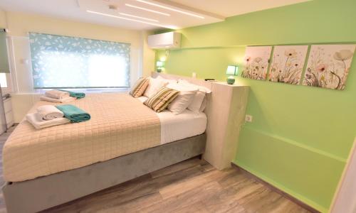 a green bedroom with a bed with towels on it at EREA Homes Apartments in Eretria