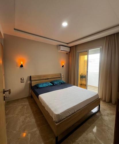 a bedroom with a large bed in a room at Résidence Nafissa Ezzahra Kelibia in Ḩammām al Ghazzāz