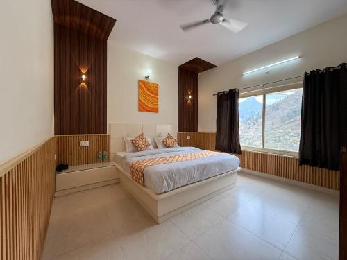 a bedroom with a bed and a large window at Mandola Stays in Chamoli