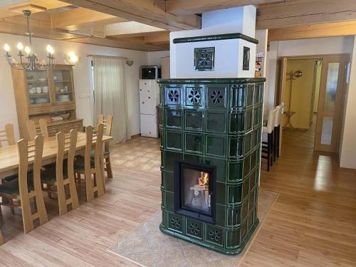 a fireplace in the middle of a room with a dining room at Chalupa ALMA in Žacléř